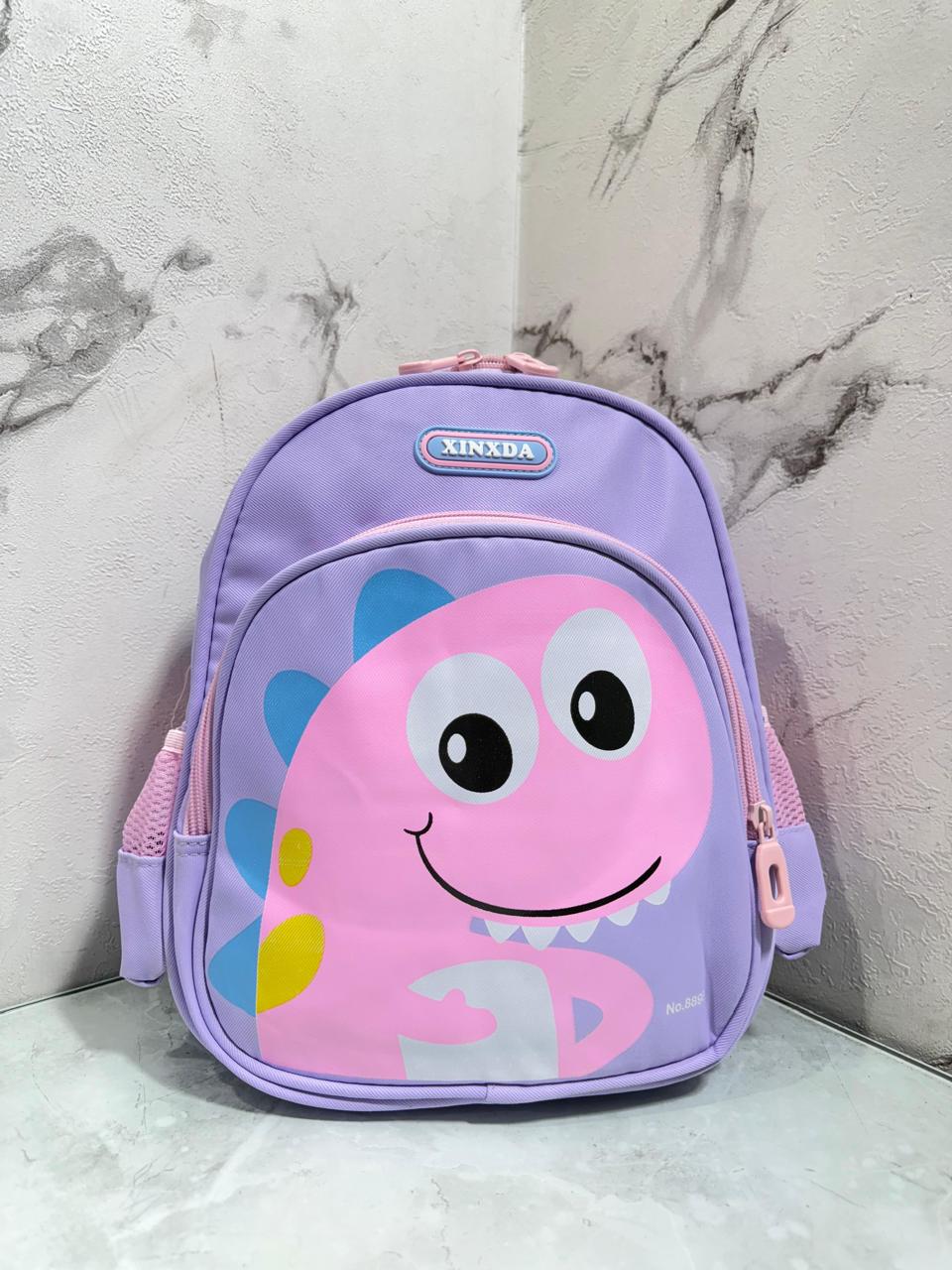 Divertido morral infantil con diseño de dinosaurio sonriente, ideal para los más pequeños . Sus colores llamativos y estilo tierno lo hacen perfecto para el jardín, colegio o paseos diarios
