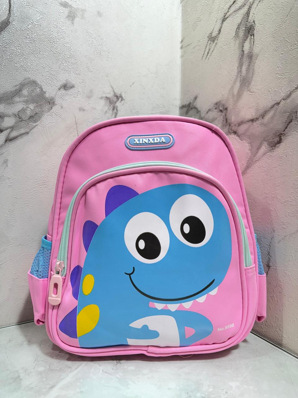 Divertido morral infantil con diseño de dinosaurio sonriente, ideal para los más pequeños . Sus colores llamativos y estilo tierno lo hacen perfecto para el jardín, colegio o paseos diarios